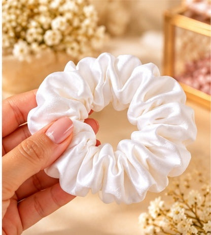 Close-up of a white gathered hair scrunchie held in hand