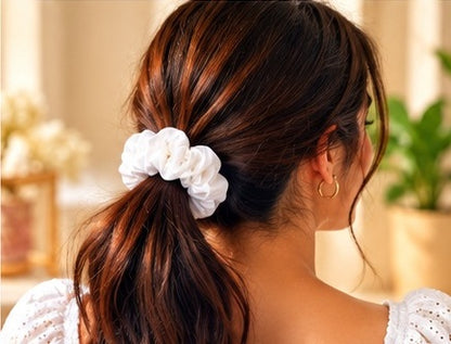 Back view of a ponytail styled with a white hair scrunchie
