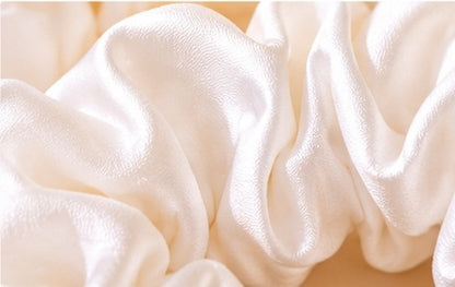  Close-up detail of the shiny white fabric texture of a scrunchie

