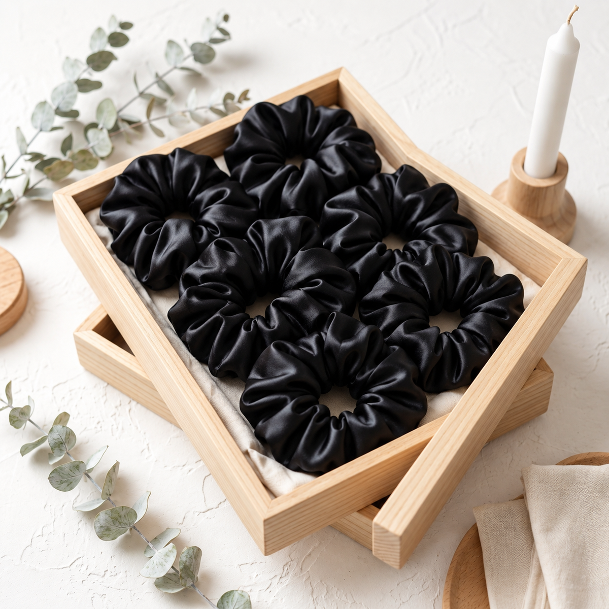 Pack of six black regular-size hair scrunchies arranged in a wooden tray