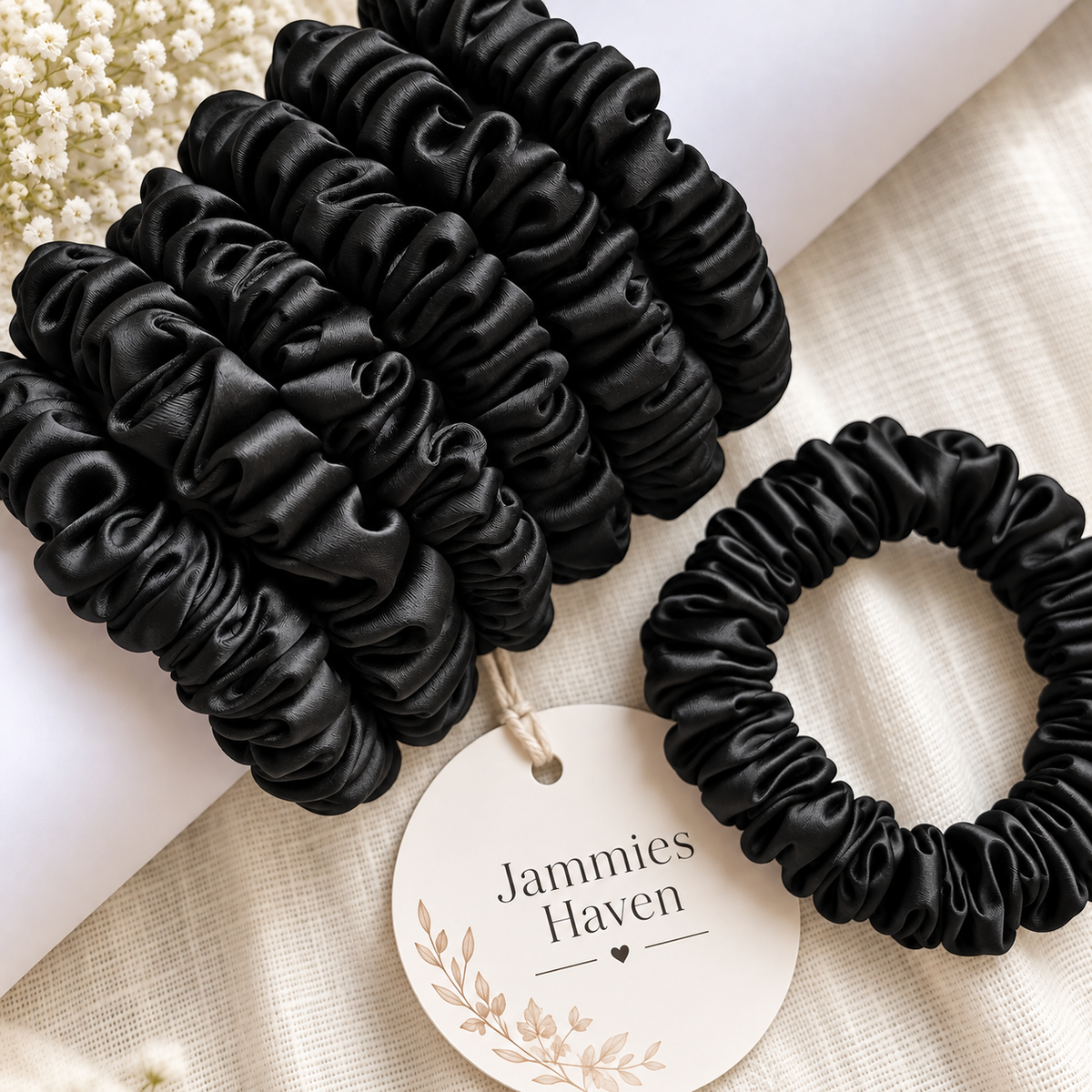 Pack of 6 black slim hair scrunchies arranged on a neutral background