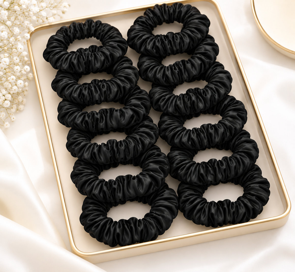 Pack of black slim hair scrunchies arranged in a tray